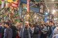 Man dressed in happi jacket holding a smartphone in the crowd of Tori-no-Ichi Fair.