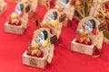 Auspicious rake of tori-no-ichi fair ornated with Japanese folklore lucky charms on a masu cup.