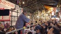 Pan right video of Japanese men in happi jacket and women in kimono doing an auction at the Tori-no-Ichi Fair of Ootori shrine.