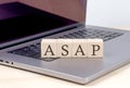 ASAP word on wooden block on laptop, business concept