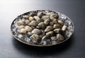 Asari clams and ice in a plate on a black background Royalty Free Stock Photo