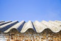 Asbestos roof above an old brick wall Royalty Free Stock Photo