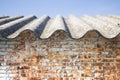 Asbestos roof above an old brick wall