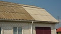 Asbestos roof replacement and repair. A close-up of an old asbestos roof with a new replaced asbestos tiled roofing part