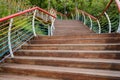 Ascending hillside planked stairway with colorful steel railings