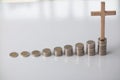 ascending pile of coins with a cross on top is the concept of life insurance for health care and accumulation of benefits for the Royalty Free Stock Photo