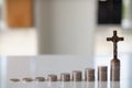 ascending pile of coins with a cross on top is the concept of life insurance for health care and accumulation of benefits for the Royalty Free Stock Photo