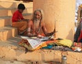 Ascetic Looks Up From Morning Newspaper, Varanasi, India