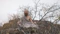 Ascetic yogi sitting in meditation on the rock