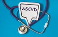 ASCVD - acronym on white figure sheet on a blue background with a stethoscope