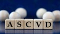 ASCVD - acronym on wooden cubes on a blue background with wooden balls