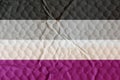 Asexual pride flag on an uneven textured surface.
