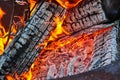 Ash covered logs with yellow and orange flames close up background asset