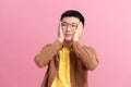 Ashamed man smiling covering his face with hands isolated on a pink background Royalty Free Stock Photo