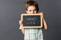 Ashamed preschool boy informing about head lice at school Royalty Free Stock Photo