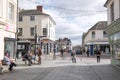 Ashford, Kent, United Kingdom - March 9, 2020: People standing, sitting and talking on High Street in the pedestrianised town