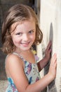 ashion little girl is standing against home house wall in garden