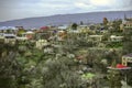 Ashtarak with medieval churches and flowering apricot trees against the background of a darkened sky,among the snow-capped mountai Royalty Free Stock Photo