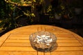 Ashtray full of cigarette butts on a wooden table Royalty Free Stock Photo