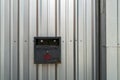 An ashtray mounted on an exterior corrugated metal wall Royalty Free Stock Photo