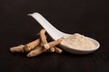 Ashwagandha root and powder in white spoon on dark background. Royalty Free Stock Photo