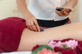 Asia beauty woman lying down on massage bed with traditional balinese hot stones along the spine at Thai spa and wellness center,