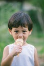 Asia boy he mouth aftertaste from eating chocolate ice cream or chocolate dessert. A sweet-toothed child eat chocolate. Kid with