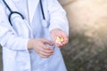 Asia boy wearing a medical suite and place doctor stethoscope on his neck. A boy pouring some drugs on his hand to a small cup. Royalty Free Stock Photo