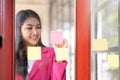 Asia business woman brainstorming and working in modern office workplace with sticky notes or post it at windows Royalty Free Stock Photo