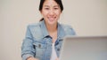 Asia business woman feeling happy smiling and looking to camera while relax at home office. Young asian woman working using laptop Royalty Free Stock Photo