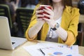 Asia businesswoman in office holding the red cup of coffee