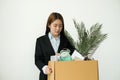 Asia businesswoman is upset by dismissal in packing belongings company into cardboard box Young women stress disappointed by