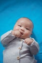 Asia Chinese adorable cute toddler baby boy son child have fun innocent careless childhood pure lying on mat pad eat hand Royalty Free Stock Photo