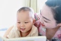 Asia Chinese Mom toddler baby boy son read book indoor home teaching early education lying on bed maternal love family Royalty Free Stock Photo