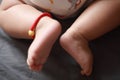 Close-up body parts baby infant chubby feet foot toes on golden ankle chain black isolated background innocent pure happy smile Royalty Free Stock Photo