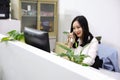 Asia Chinese office lady woman girl on chair make a call use desk phone chat work smile wear business occupation suit workplace Royalty Free Stock Photo