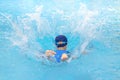 Asia cute boy wearing swimming suit and goggles jump into swimming pool. Healthy kid enjoying active lifestyle. Refreshing and Royalty Free Stock Photo