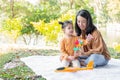 Asia daughter playing colorful windmill with mom in the park. Family outdoor activity. The kid sitting on the floor with her Royalty Free Stock Photo