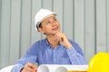 Asia Engineer smile thinking, young man and looking away while sitting at container box background