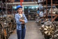 Asia engineer woman worker wears a safety helmet and holding tablets. Crossed arm and standing in the automotive spare parts Royalty Free Stock Photo