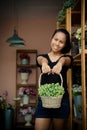 Asia female owner holding basket with yellow and green flower