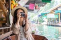 Asia female tourists wearing hat holding camera and smartphone take photo vlog live . Beautiful woman take taxi boat visiting