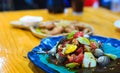 Food is spicy and cockles, lemon, chilli and tomato in dish.