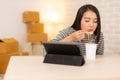 Asia freelance business woman eating instant noodles while working on laptop in living room at home office at night. young Asian