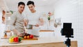 Asia gay couple blogger vlogger and online influencer recording video content on healthy food in kitchen at home. Young LGBT men Royalty Free Stock Photo