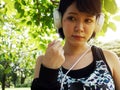 Asia girl sport listening to music in the public park.