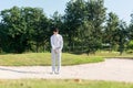 Asia Golfer man hitting out of a sand trap. The golf course is on the sand. Royalty Free Stock Photo