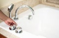 Asia hotel classic luxury bath with hand holding bath tub or faucet on white ceramic in a retro style. Modern style chrome Royalty Free Stock Photo