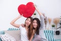 Asia lesbian lgbt couple holding red heart pillow together over