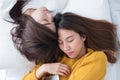 Asia lesbian LGBT Couple lay on bed and close eye with happiness